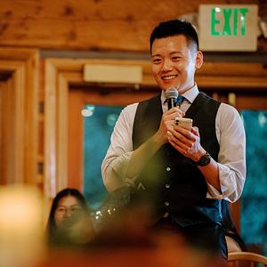 Jerry Zhou 周洁瑞,微笑着拿着话筒
